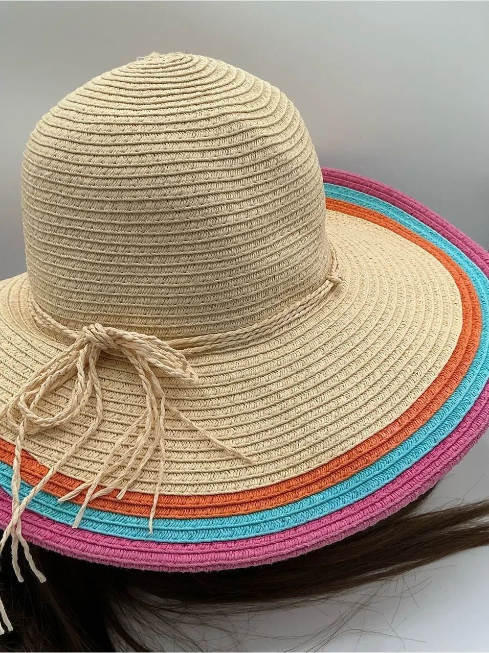 Beige straw hat featuring blue, orange, and pink colors along the brim